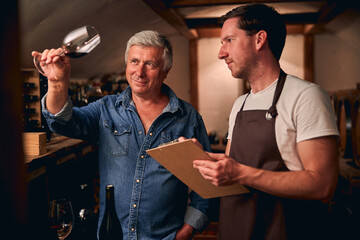 Smiling Caucasian male adults working in winery manufacture