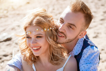 Portrait of a young couple sitting on the beach.