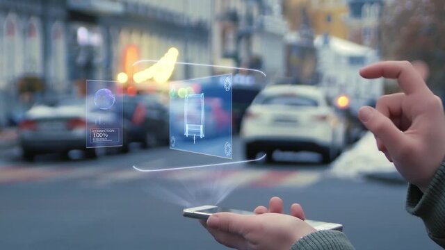 Female hands on the street interact with a HUD hologram Trailer house. Woman uses the holographic technology of the future in the smartphone screen on the background of the evening city