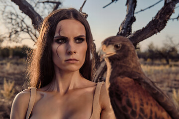 Beautiful woman posing on nature with eagle