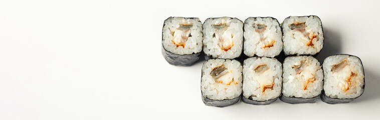 Sushi roll with eel on a white plate, classic Japanese sushi. Traditional Japanese food with maki. Delicious pieces of sushi. For the restaurant menu. copyspace