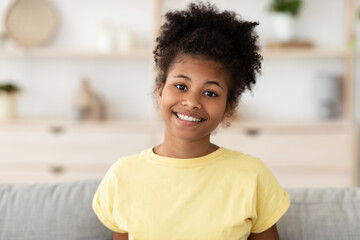 Cheerful African Girl Posing Sitting On Sofa At Home