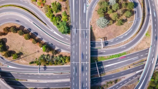 Highway interchange aerial hyperlapse timelapse with cars moving fast in the complex intersection as the top down view moves higher and reveals more connections. Interstate traffic 4k video footage