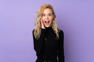 Young blonde woman isolated on purple background with surprise and shocked facial expression