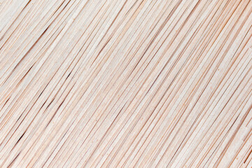 Background of brown soba noodles close up. Asian cuisine, buckwheat pasta, raw, uncooked, dried, natural, organic, vegetarian healthy food. Striped surface.