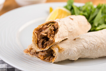 Turkish shawarma Tantuni in pita bread on wooden table. Turkish Fast food