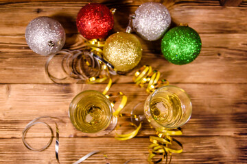 Two wineglasses with champagne and different christmas decorations on wooden table. Top view