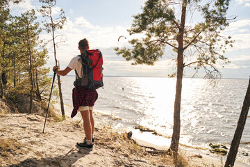 Male with rucksack going nordic walking in nature