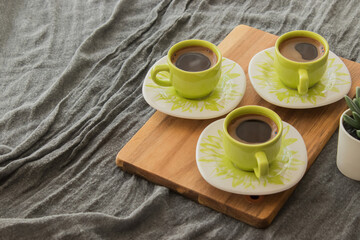 Turkish coffee standing on wooden piece. Gray cover in the background