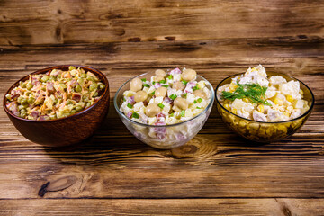 Set of festive mayonnaise salads on wooden table