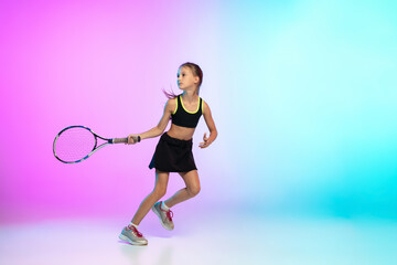 Fototapeta na wymiar Aspiration. Little tennis girl in black sportwear isolated on gradient background in neon light. Little caucasian model, sport kid training in motion and action. Sport, movement, childhood concept.