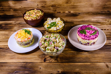 Set of festive mayonnaise salads on wooden table