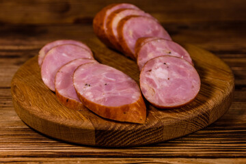 Cutting board with sliced sausage on a wooden table