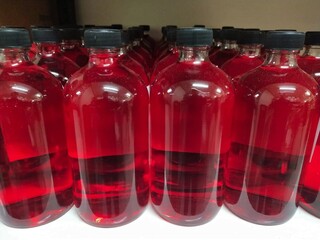 Glass bottles containing red reagents are waiting to be labeled in the production building.