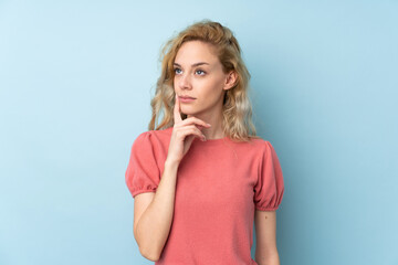 Young blonde woman isolated on blue background thinking an idea