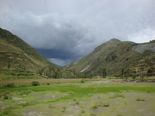 Fototapeta na wymiar Villages and stonework near Cusco, Peru. sky green stone structures buildings fountains