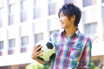 サッカーボールを持つ男子大学生 © Paylessimages