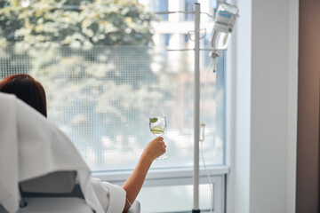 Female with a glass of beverage undergoing a medical procedure