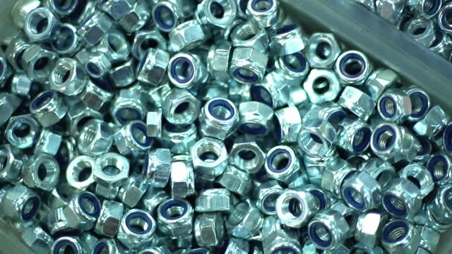 The boxes filled with bolts, nuts aand screws. Close up shot in automotive parts factory warehouse. raw materils depot.