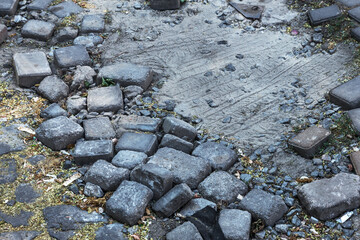 Broken pavements sidewalks on the sidewalk. pavement with paving slabs with defects and cracks going in perspective. The road from the stone, which begins to sink, and created a depression