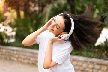 Young woman listening music at outdoors