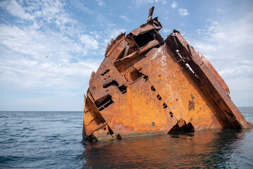 The rusty remains of a sunken ship .