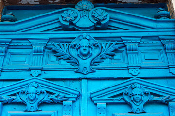 Old wooden door. Ancient antique wooden in an old wall. Ancient decorative wooden door. Historical art style facade of an elite expensive antique door. Wooden background, old front door, vintage eleme