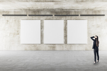 Businesswoman looking on three blank posters