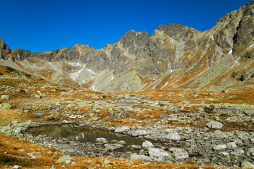 Mountain lake between rocks on a clear autumn day