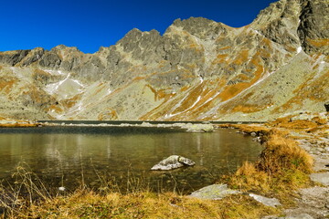 Pathway on the shore of a mountain lake in autumn