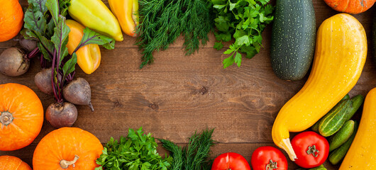 Harvest. Autumn vegetables on a wooden background. Vegan food. The layout is a top view. Banner.