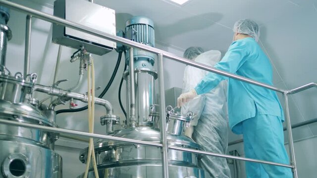 Fermentation reactor is being handled by male medical experts