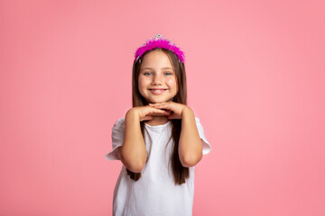 Obraz na płótnie Canvas Childhood, beauty and fashion. Cheerful little girl with crown enjoys beauty