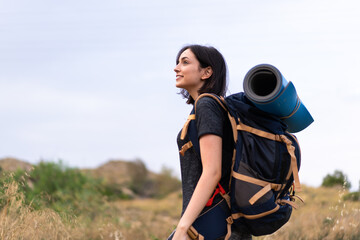 Young mountaineer girl with a big backpack at outdoors
