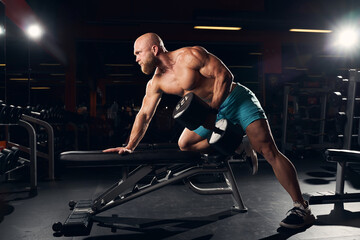 Naklejka na ściany i meble Sporty bald man working out in the gym
