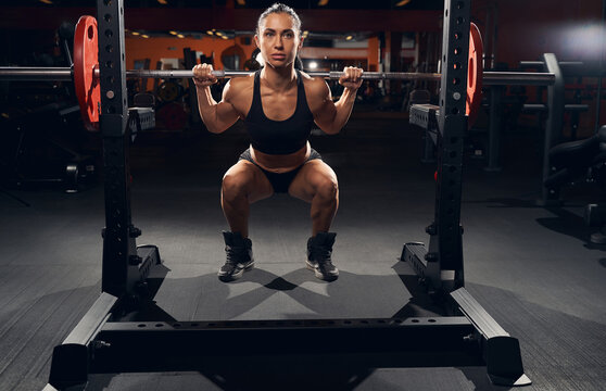 Strong Female Athlete Doing Squats With A Barbell