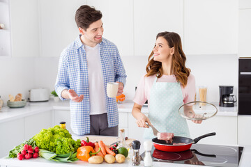 Portrait of two nice lovely attractive cheerful cheery spouses making domestic fresh homemade dish cookery culinary in light white interior kitchen house apartment indoors