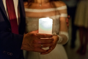bride and groom holding candles