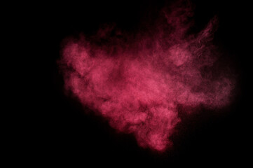 Red and pink powder explosion on black background. Colored powder cloud. Colorful dust explode. Paint Holi.