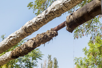 Overground heat pipes. Pipeline above ground, conducting heat for heating city. City aerial overground heating main in metal thermal insulation in residential city quarter. Open laying mains on poles