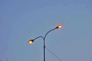 Street lamp silhouette from low angle during dawn.