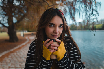Close up shot of a pretty caucasian woman holding a cup of coffee to go