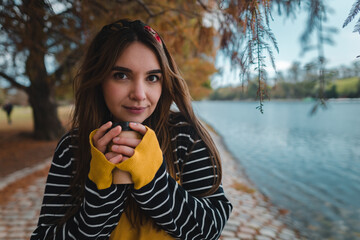 Close up with copy space of a pretty caucasian woman holding a cup of coffee to go.