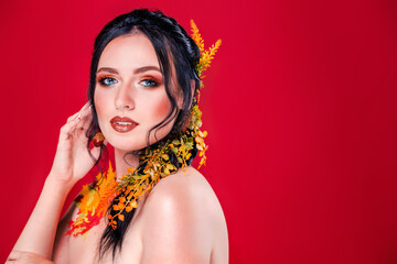 Trendy autumnal makeup . Fashion beauty model girl. Closeup portrait isolated on red background with copy space