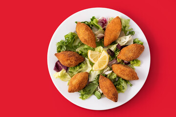 Traditional lebanese kibbeh on red background. Top view