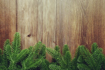 Naklejka premium Christmas background with fir tree branches border frame on wooden background 