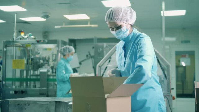 Pharmaceutics worker is filling boxes with medical products