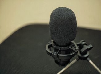Close up of a microphone with yellow wall background