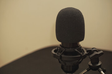 Close up of a microphone with yellow wall background