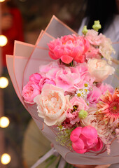 Fresh beautiful flower. Woman holding a big delicate flower bouquet of roses, peony, astilbe and others in pink colors.